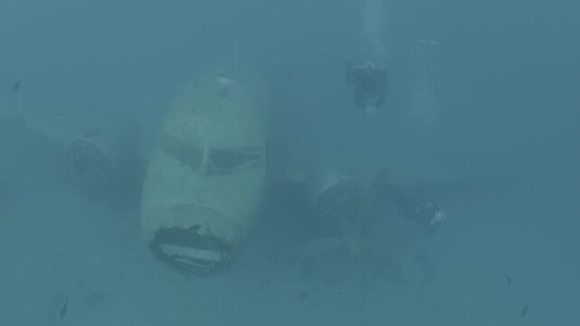 log footage of scuba divers are exploring a c47 dakota airplane wreck underwater 