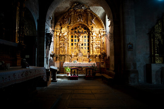 Illuminated altar in a dimly lit church.. Parish Church of Our Lady of the Assumption in La Alberca, Salamanca, Spain