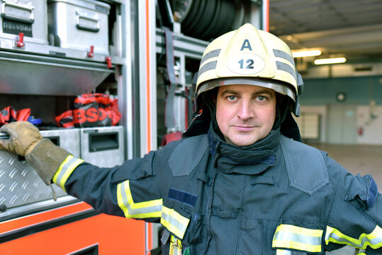 Portrait of confident firefighter in front of fire engine