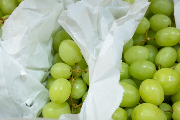 fresh green grapes in white paper bag