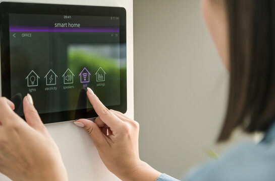 Young woman with tablet with smart home control functions