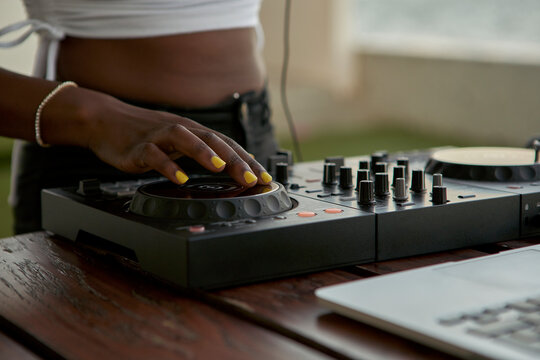 Crop view of DJane working on mixing board