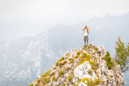 Italy, Massa, man standing on top of a peak in the Alpi Apuane mountains