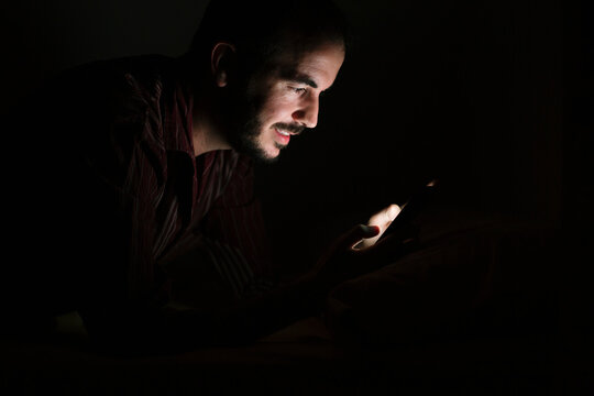 Man using smartphone at night