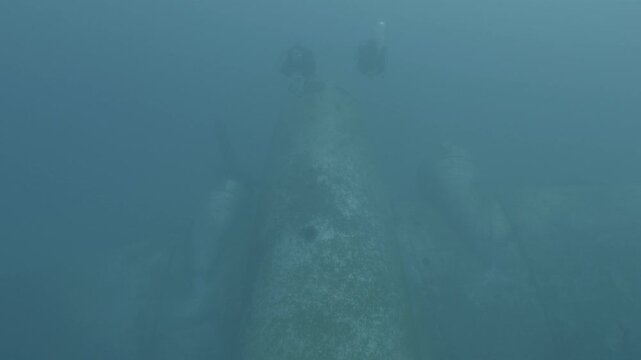 log footage of scuba divers are exploring a c47 dakota airplane wreck underwater 