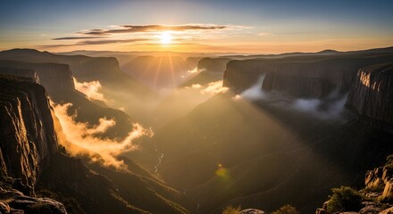 Golden sunrise over misty mountain canyon with winding river