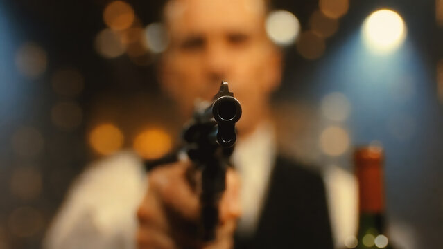 Dramatic Close-up of a Revolver Pointed at Camera with Blurred Man in Suit in Background
