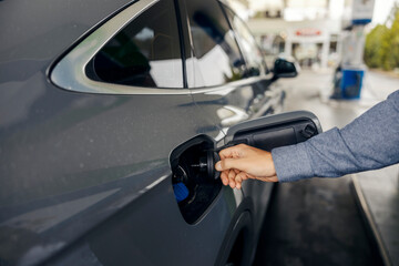 Person refueling car at gas station pump