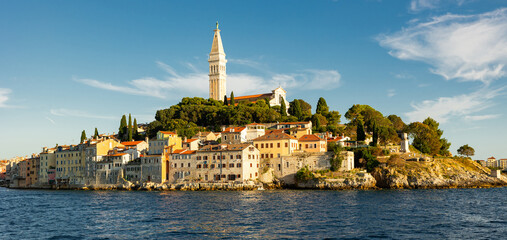 Bell tower of Church of St. Euphemia rises above city of Rovinj, citys dominant feature. Citys architecture and nature attract tourists. View of city from boat. © JackF