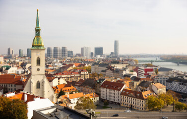 Panoramic view of Bratislava showcasing St. Martins Cathedral, Danube River, modern skyscrapers, and historic rooftops on autumn day, Slovakia