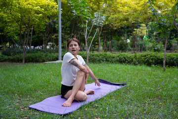 Beautiful young woman practicing Padmasana on yoga mat outdoors, space for text. © seksan94