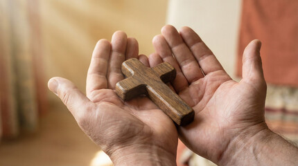 Hands holding wooden cross in sunlight with concept of easter  