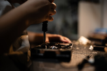 Technician repairing electronics device with screwdriver