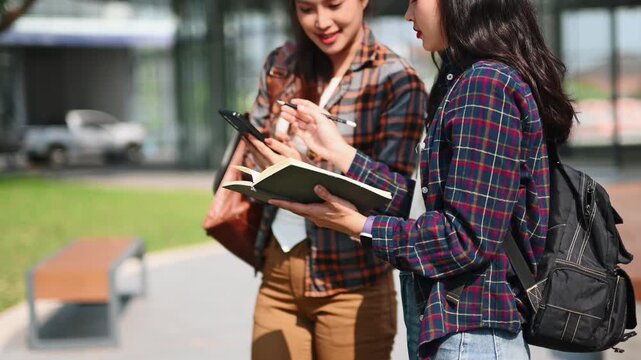 Asian students using smartphone and tablet at modern campus. Social media, digital communication, online networking and Gen Z lifestyle