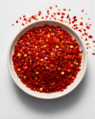 Top View of a Bowl of Spicy Red Pepper Flakes on White Background