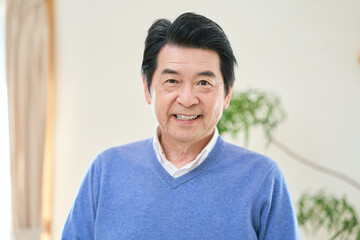 Obraz premium 部屋で笑顔で立つアジア人シニア男性
