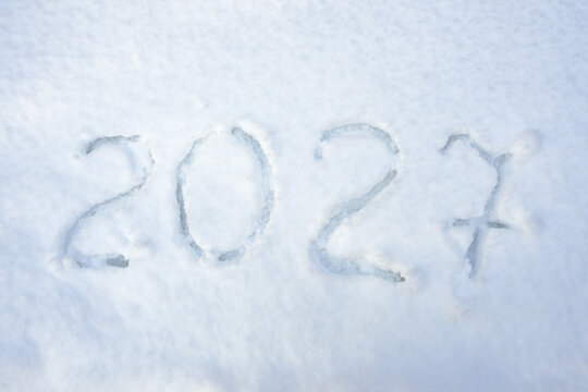 Handwritten inscription 2027 in real white snow, concept photography with number symbol for the upcoming Christmas and New Year holidays