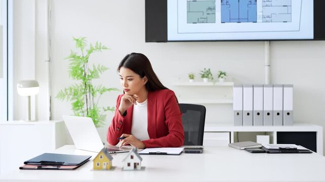 Young professional real estate agent working on laptop pc sitting at desk in modern office space. woman using computer technology app for work online.