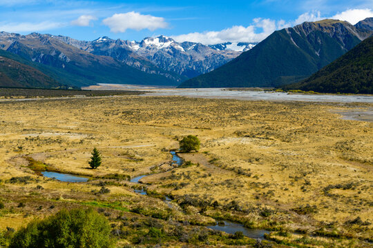 Large river flood plain with snow covered mountains in the background