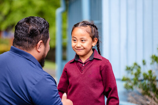 Happy Samoan boy with braided hair looking at dad