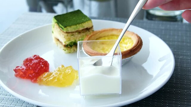 Yogurt portioned taken by the teaspoon desserts at the hotel breakfast buffet Portuguese pastries green cake jam