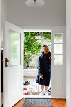 Teenage Samoan girl leaning against the door frame