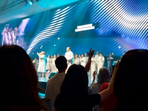 Contemporary church worship scene in blur, believers raising hands in prayer and praise. BSD, Indonesia - February 22, 2026