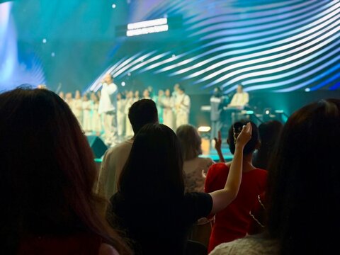 Contemporary church worship scene in blur, believers raising hands in prayer and praise. BSD, Indonesia - February 22, 2026