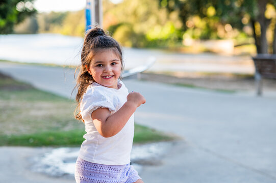 A young girl with long hair moves quickly along a path