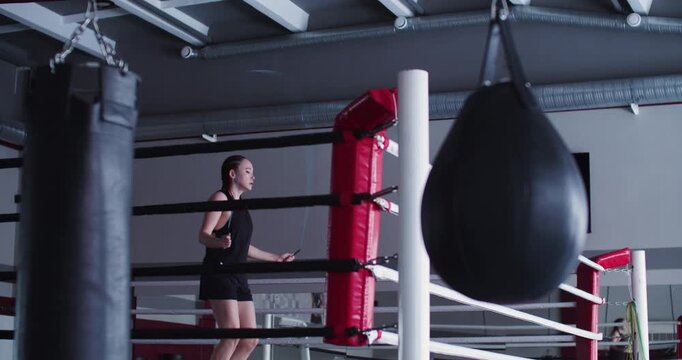 Watch a focused woman boxer performing a jump rope workout, enhancing agility, coordination, and stamina while building the foundation for powerful boxing performance.