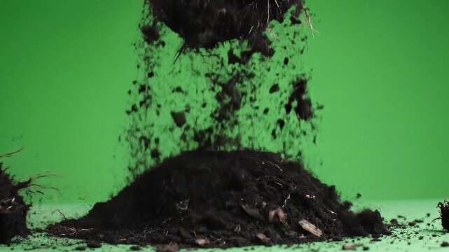 Dynamic visual of rich, dark soil actively falling and accumulating into a fresh mound against a vivid green backdrop, embodying concepts of growth, cultivation, and raw earth's fertility