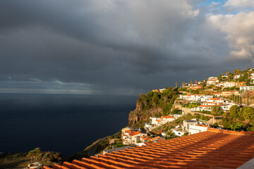 Malownicza zabudowa na wzgórzu skąpana w złotym świetle pod dramatycznym niebem © Kamil_k2p