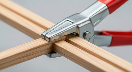 Metal clamp securing wooden beams joinery construction close-up precision carpentry tool workshop detail