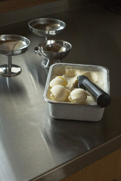 Scoops of homemade lemon ice cream on a steel table