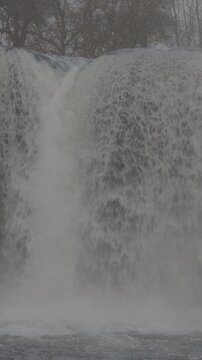 Hermosa cascada ancha fluyendo hacia un r&iacute;o turquesa en paisaje natural