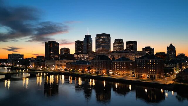 Serene twilight skyline of rochester, new york with illuminated buildings reflecting on the river