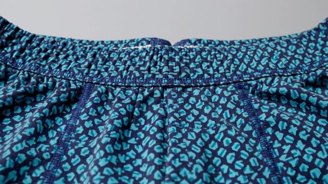 Close up view of the elastic waistband and patterned fabric of men's boxer shorts