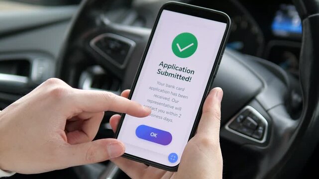 Person applying for a credit card on a smartphone in a car. Hand clicking Apply, processing animation, and success screen. Perfect for fintech, digital banking, and mobile commerce. Fast and modern