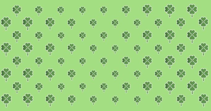 Digital animation of multiple clover leaves moving against green background