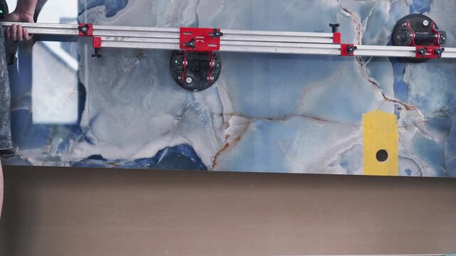 Master tilers carry a huge large-format tile of XXL size. Professional vacuum tile transport. Professional tile work, bathroom renovation, laying blue tiles, slow motion