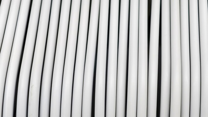 Obraz premium Close-up of a roll of white filament for 3D printing, showcasing its consistent texture and parallel lines