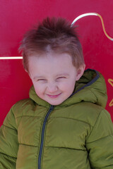 Boy playing on playground, posing in camera with your eyes closed