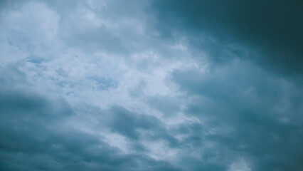 A dramatic and expansive overhead view of dark, heavy storm clouds filling the entire sky, creating...