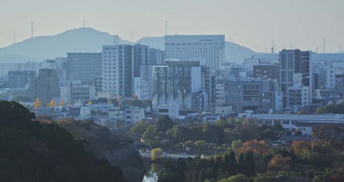 Epic view of hazy Japanese city early in the morning and surrounded by autumn trees