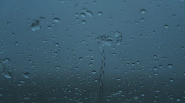 車の窓に落ちるみぞれ交じりの雨