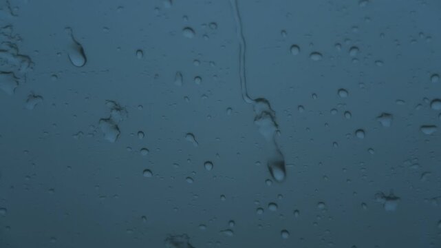 車の窓に落ちるみぞれ交じりの雨