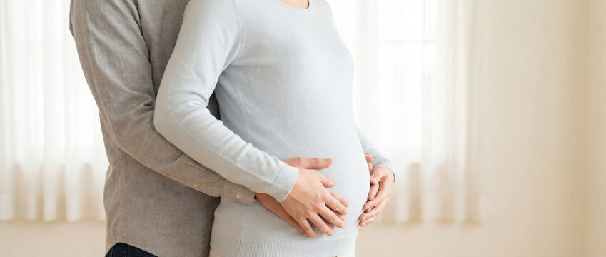 Pregnant woman and partner holding baby bump and embracing at home, intimate maternity moment, expecting parents and family pregnancy.