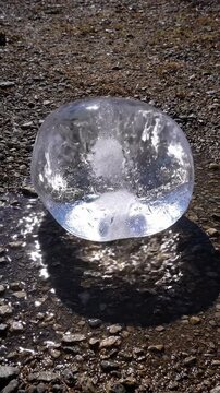 Large ice block sublimates and changes shape over time while melting on ground