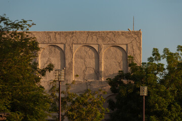 Views of Oriental buildings, sandstone walls and arches, windows and doors. On the streets of Dubai, in a public place.
