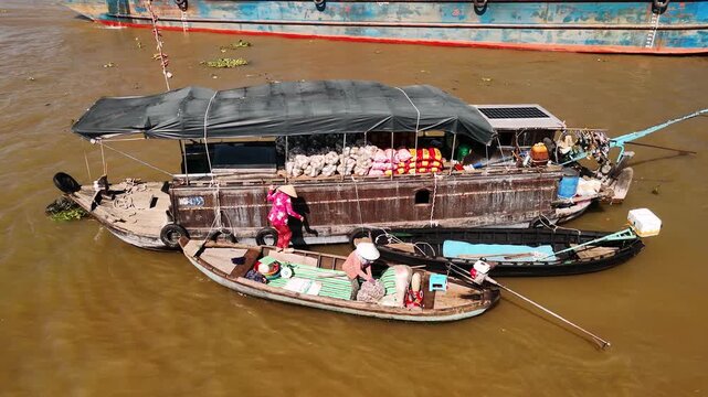 Vendors trading between boats at cai rang floating market in the mekong delta, can tho, vietnam